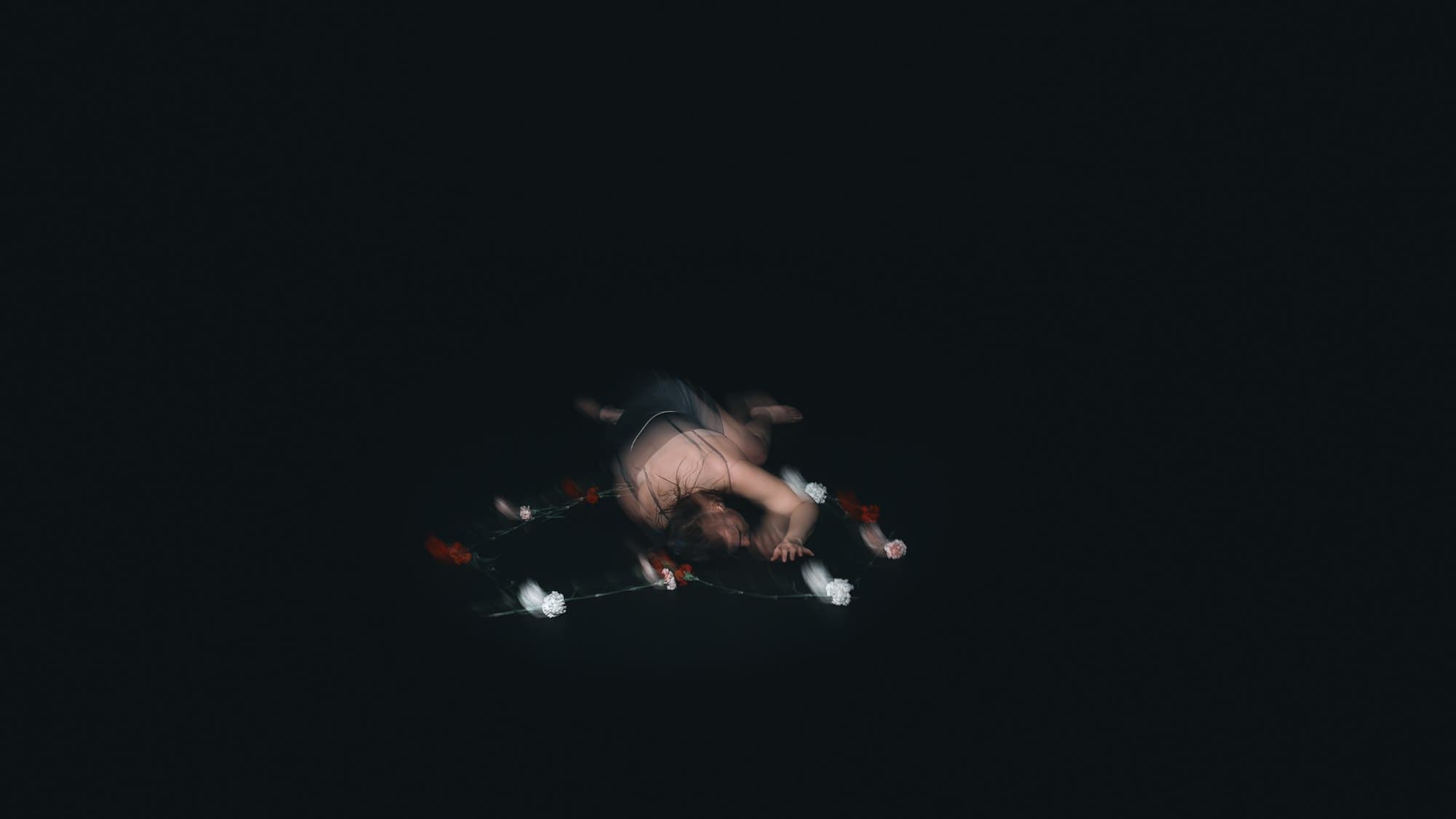 Laura curled on the dark floor among scattered flowers