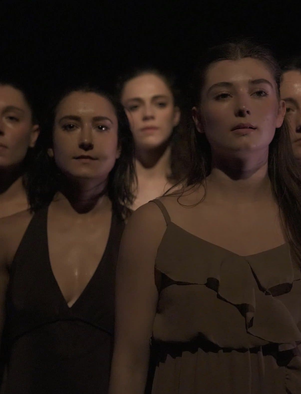 Three dancers looking straight at the audience