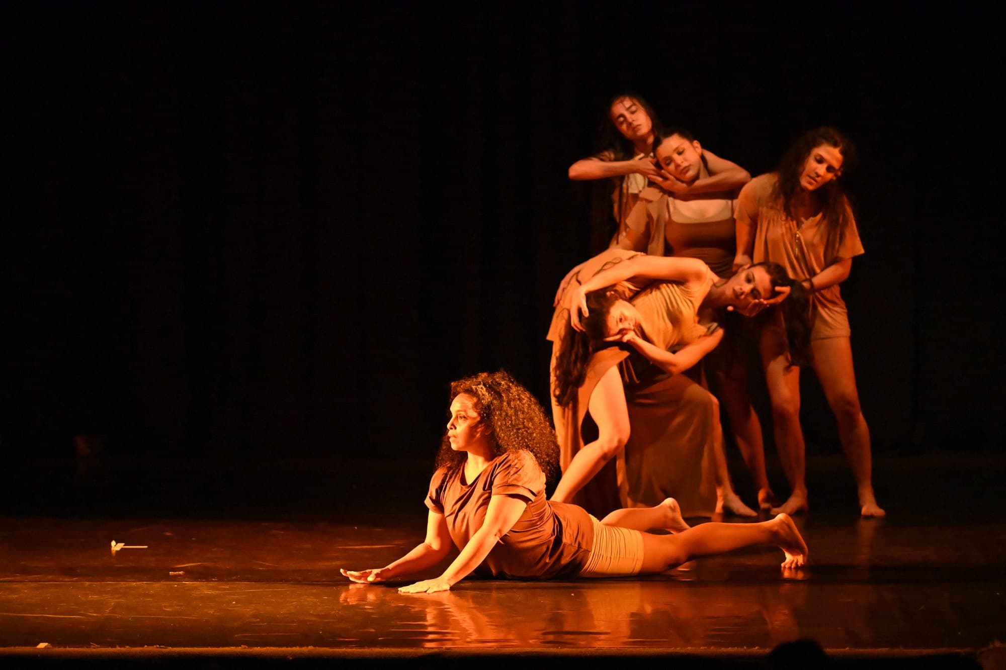 The Asunción cast in a tableau on stage, one dancer lying downstage