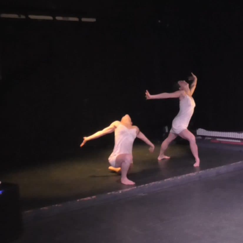Two dancers moving apart on stage
